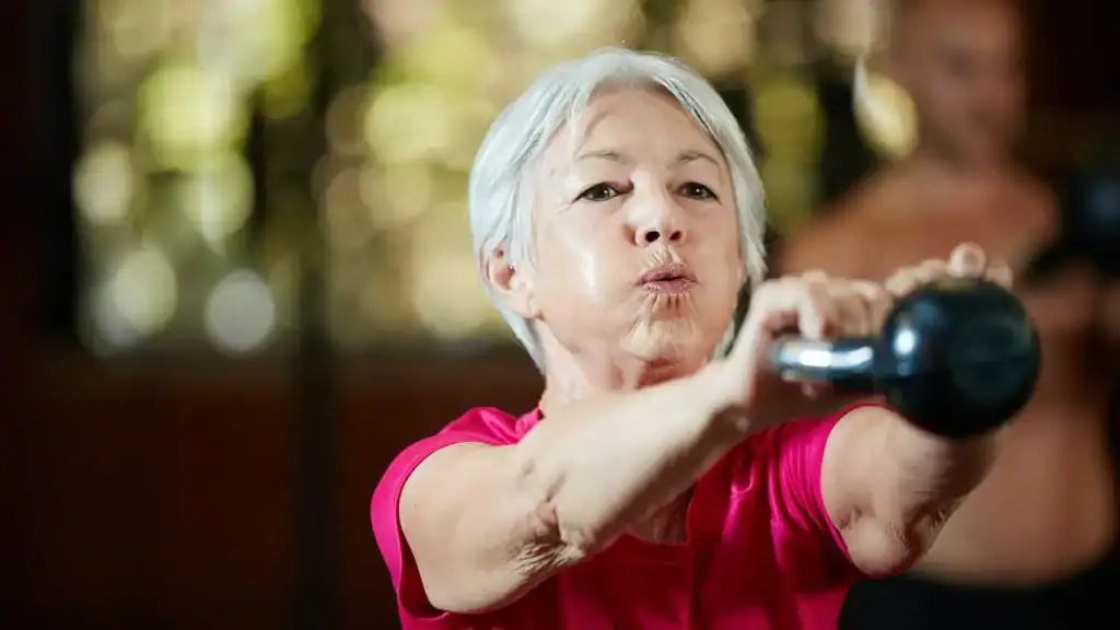 Toning Arms After 60: Empowering Womens Fitness Through Effective Weight Training 1 Older woman doing weight training Shepperton Green to help her strength and longevity
