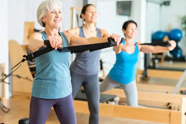 Toning Arms After 60: Empowering Womens Fitness Through Effective Weight Training 2 older woman doing weight training Shepperton Green and resistance in the gym to tone upper arms